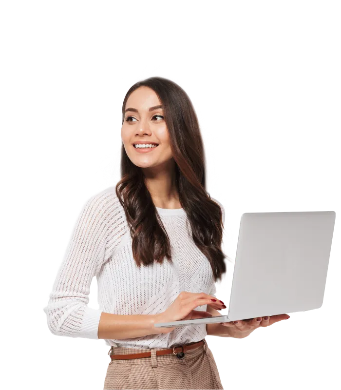 A smiling businesswoman standing and holding a laptop while looking away into the distance and away from the camera.