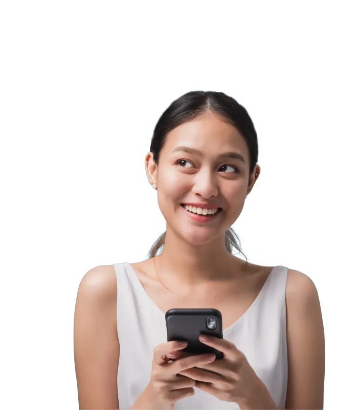 A smiling young woman holds her smartphone and looks off into the distance.